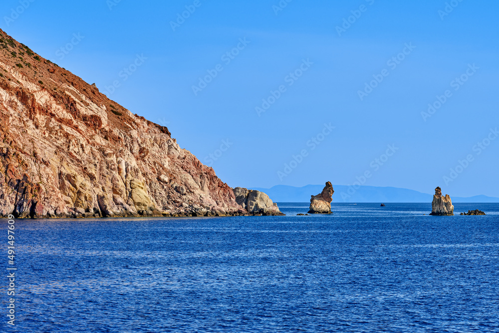 Beautiful view of high hill slope of island in Mediterranean Sea. Blue waters and sky, sunshine, summer day, distant rocks and isles in background. Beautiful view of high hill slope of island in Mediterranean Sea. Blue waters and sky, sunshine, summer day, distant rocks and isles in background.