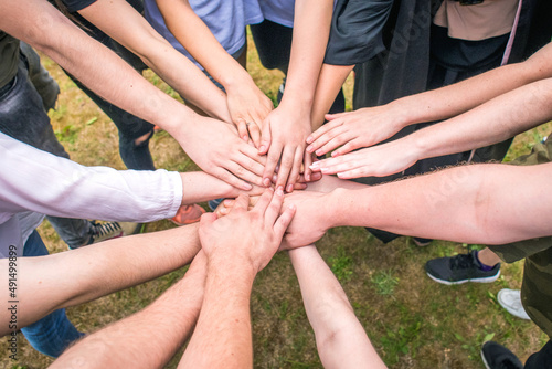 People (men and women) stretch their hands to each other, symbolizing team, teamwork, friendship, team building
