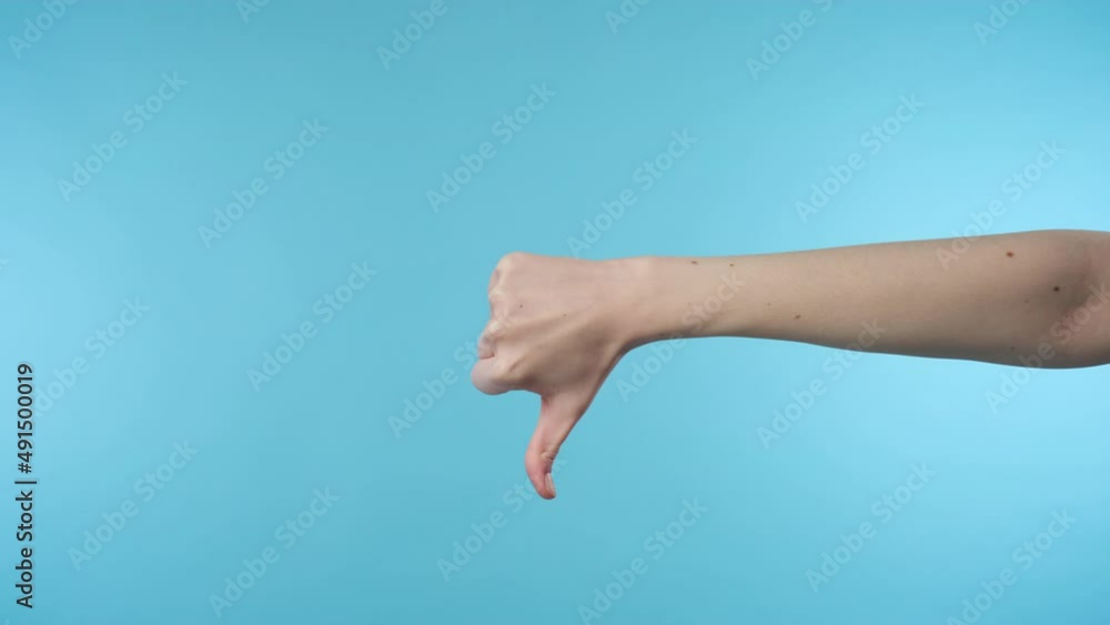 Close up of woman's hand showing thumb down sign Close up of woman's hand showing thumb down sign