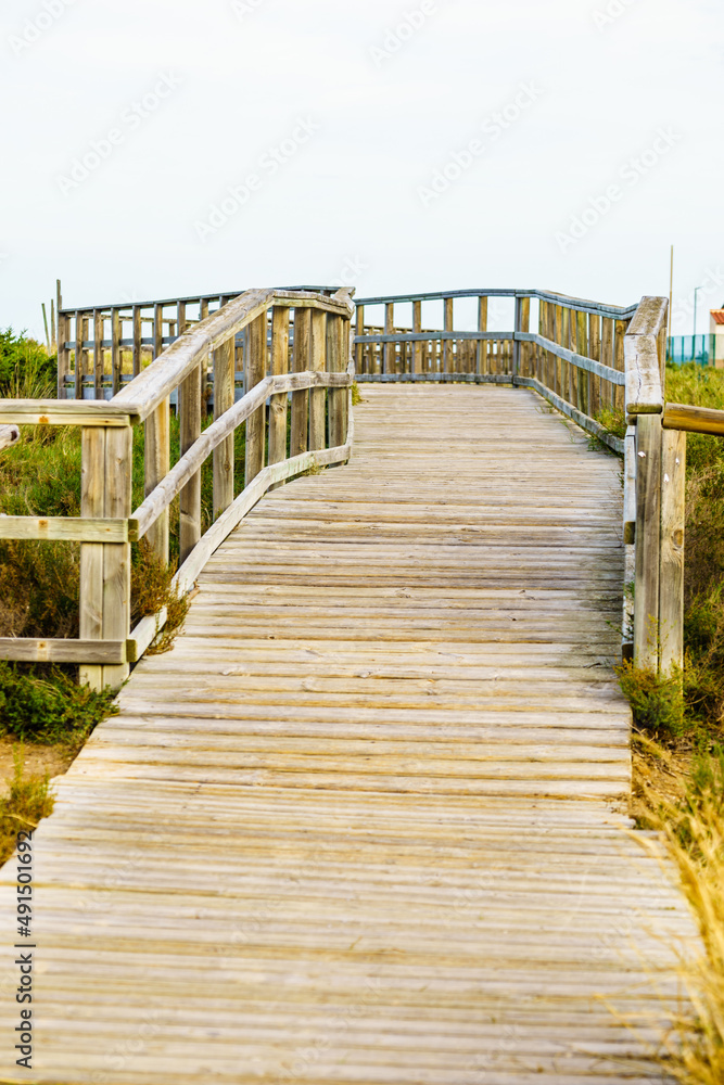 Fototapeta premium Wooden path to beach sea water.