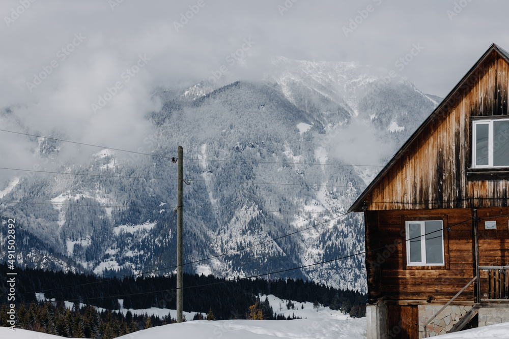 A small cozy hut located in front of the snow-capped mountains