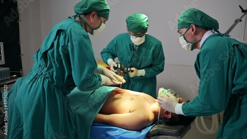 Team of doctor helping by AED defibrillation with accident injured patient unresponsive in emergency room