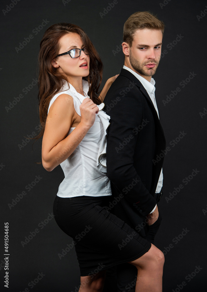 fashionable man and woman in business look on black background, colleague