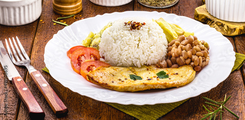 rice and beans served with french fries, grilled chicken fillet and salad, typical brazilian meal