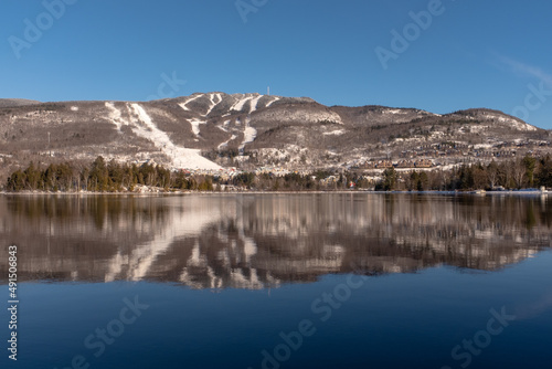 Mont-Tremblant ski slopes reflecting in a lake in winter