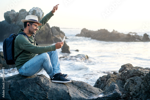 person sitting on the beach outdoors with a smartphone smiling happy