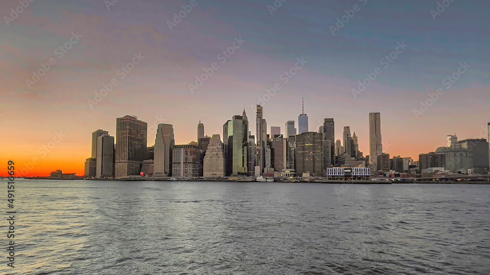 Panoramic view of Manhattan skyline during a beautiful sunset on a cold winter evening in New York City.