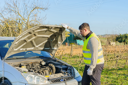 Man inspecting engine of car