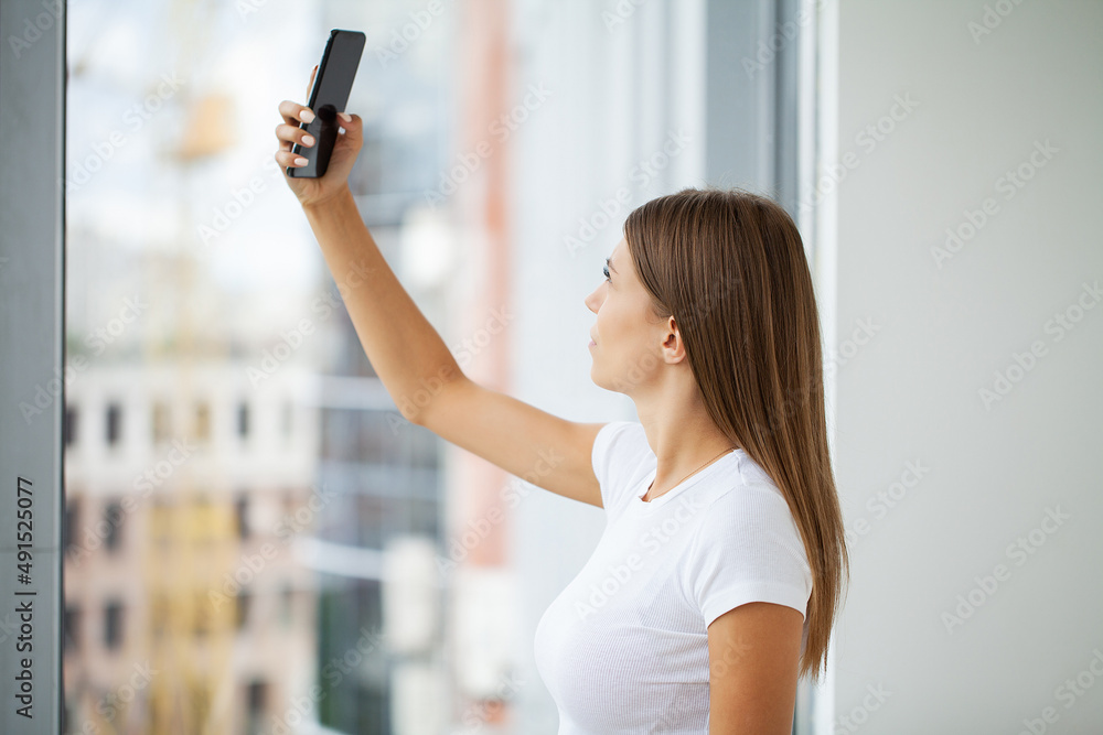 A young brunette woman looks at the mobile phone screen A young brunette woman looks at the mobile phone screen