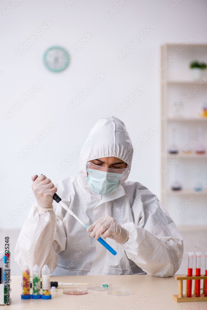 Young male chemist in drugs synthesis concept Young male chemist in drugs synthesis concept