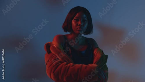Stylish dancing african american young girl rap performer cool moving in neon colourful studio light. ProRes codec