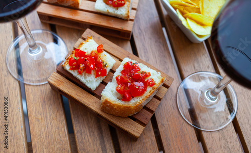 Traditional Italian bruschetta with spicy tomato salad and chips served with red wine