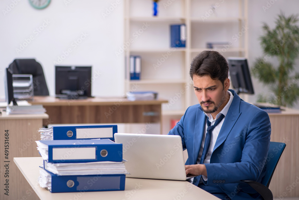Young businessman employee unhappy with excessive work in the of Young businessman employee unhappy with excessive work in the of