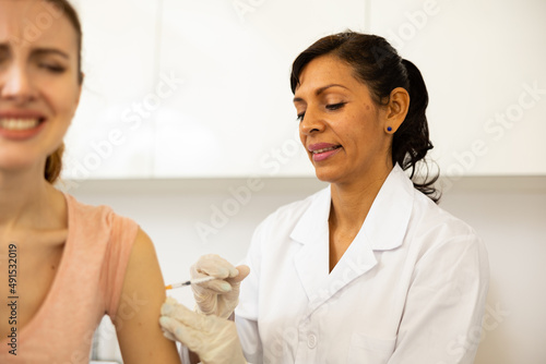 Health care concept, doctor vaccinates english woman against coronavirus at vaccination center