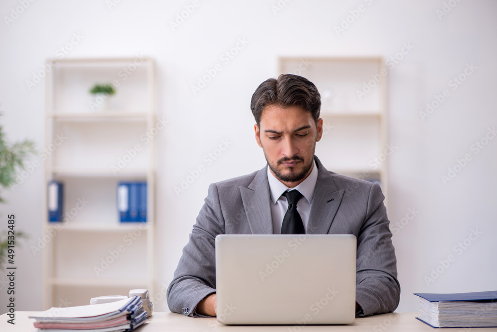 Young male employee working in the office Young male employee working in the office