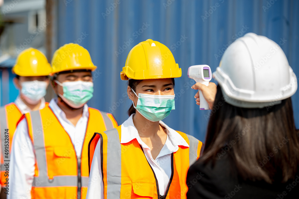 Checking the body temperature of workers by a thermometer. Checking the body temperature of workers by a thermometer.