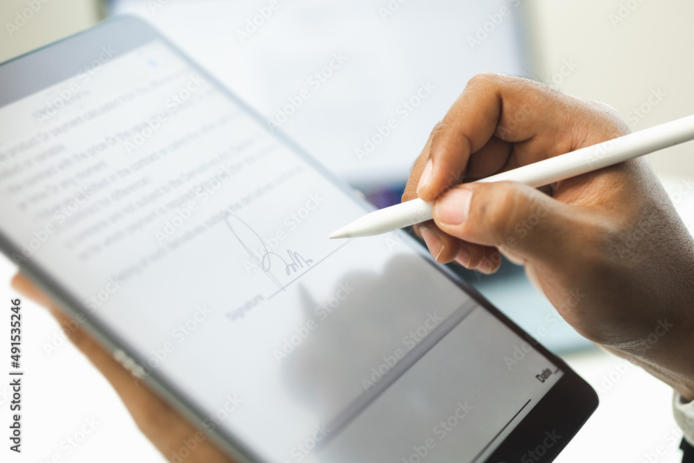 Close up businessman hand electronic Signature on Tablet by Stylus. Write business agreement of contract. Man signing contract on tablet. Business and technology concept. Close up businessman hand electronic Signature on Tablet by Stylus. Write business agreement of contract. Man signing contract on tablet. Business and technology concept.