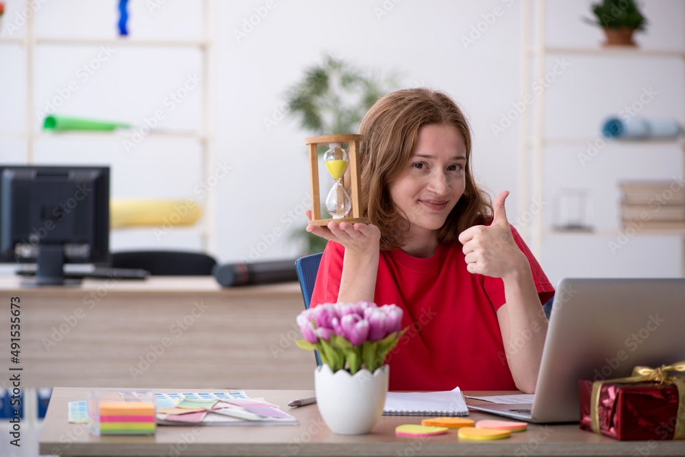 Young female designer in time management concept Young female designer in time management concept