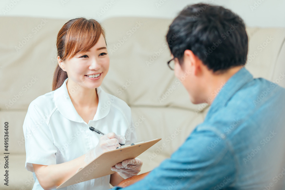 Obraz premium 問診する看護師と男性患者 