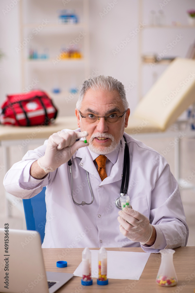 Old male doctor pharmacist working in the clinic Old male doctor pharmacist working in the clinic