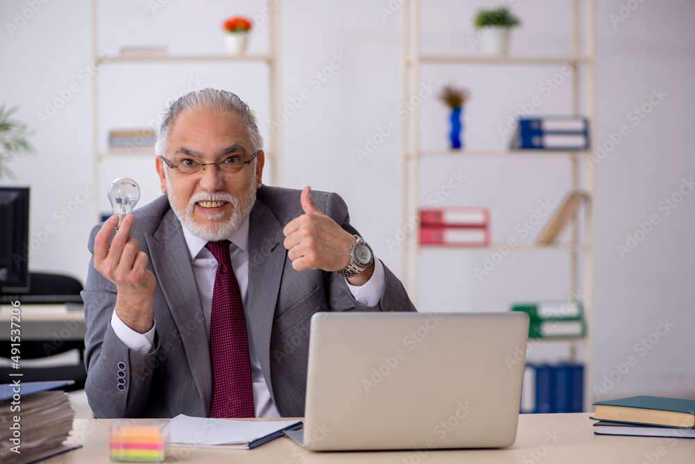 Old male employee in happy idea concept Old male employee in happy idea concept