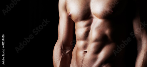 Masculinity in portrait. Studio shot of a muscular shirtless man isolated on black.