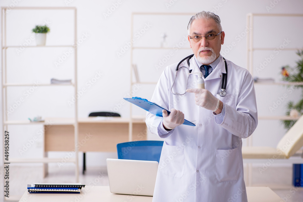 Old male doctor working in the clinic Old male doctor working in the clinic