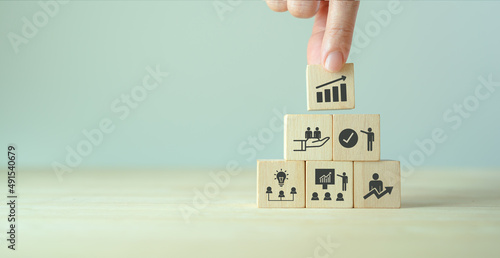 Business, personal development concept. Improving and developing  competency, performance. Hand holds wooden cubes with growth icon stading with brainstorm, training, mentor, support and improve icon photo