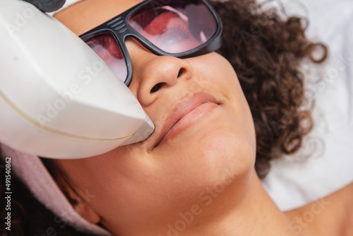 фотографія Closeup photo of Black Brazilian woman performing laser hair removal on upper li