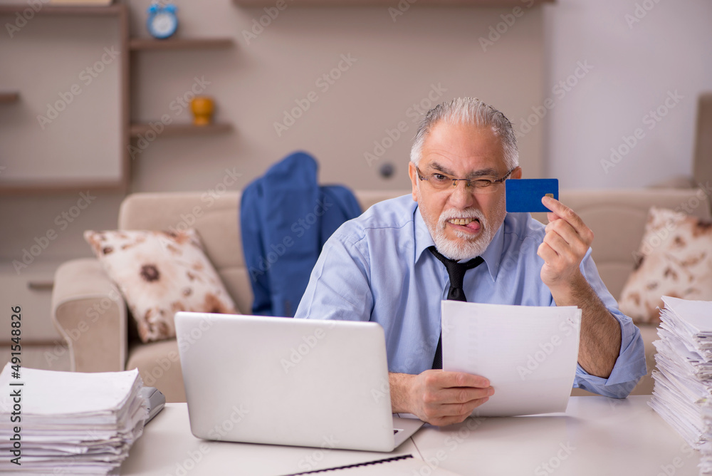 Fototapeta premium Old male boss working from home during pandemic
