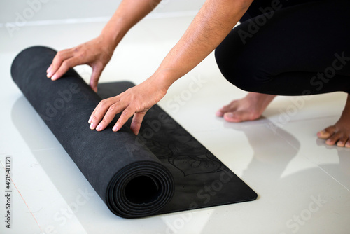  Woman hands rolling up a yoga mat.Healthy life.text space.