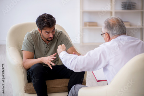 Young man visiting old psychologist