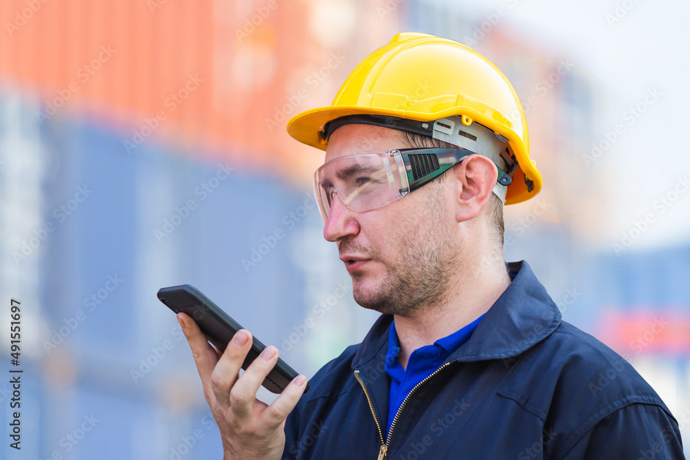 Engineer in hard hat with clipping path using mobile phone, Industrial worker using mobile smartphone in industry containers cargo Engineer in hard hat with clipping path using mobile phone, Industrial worker using mobile smartphone in industry containers cargo