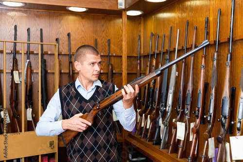 Buyer selects a combat rifle at a gun store