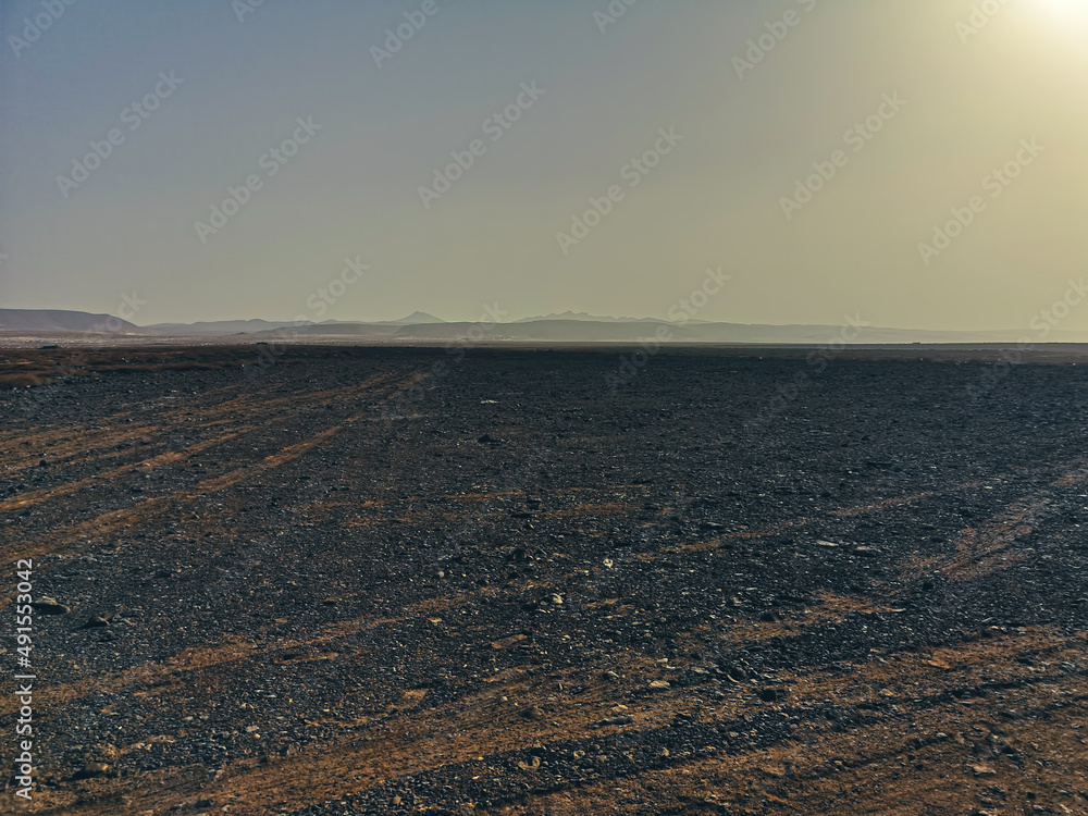 Bright lava rocks on Boa Vista Island, Cape Verde. Volcanic hills in the distance, dry arid climate, sandy terrain. Selective focus on the details, blurred background. Bright lava rocks on Boa Vista Island, Cape Verde. Volcanic hills in the distance, dry arid climate, sandy terrain. Selective focus on the details, blurred background.