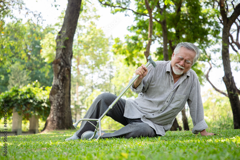 An elderly man walks and accidents while exercising in his backyard. He injured his ankle and was unable to stand up. Senior healthy and insurance concept An elderly man walks and accidents while exercising in his backyard. He injured his ankle and was unable to stand up. Senior healthy and insurance concept