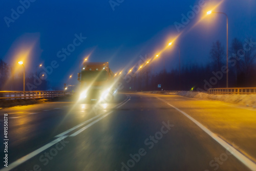 car highway early in the morning with light lanterns along the sides and a truck