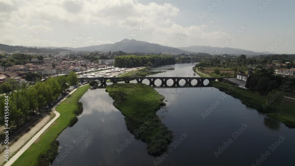Aerial backward ascending over river with medieval bridge in background. Ponte de Lima in Portugal Aerial backward ascending over river with medieval bridge in background. Ponte de Lima in Portugal