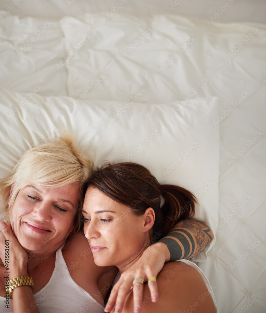 Tender morning moments. High angle shot of a loving lesbian couple lying in bed. Tender morning moments. High angle shot of a loving lesbian couple lying in bed.
