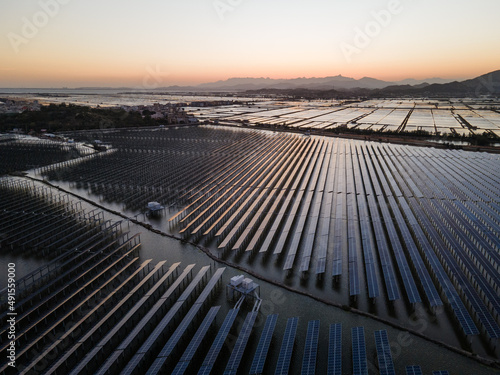 An aerial view of a solar power plant in the sea at sunset