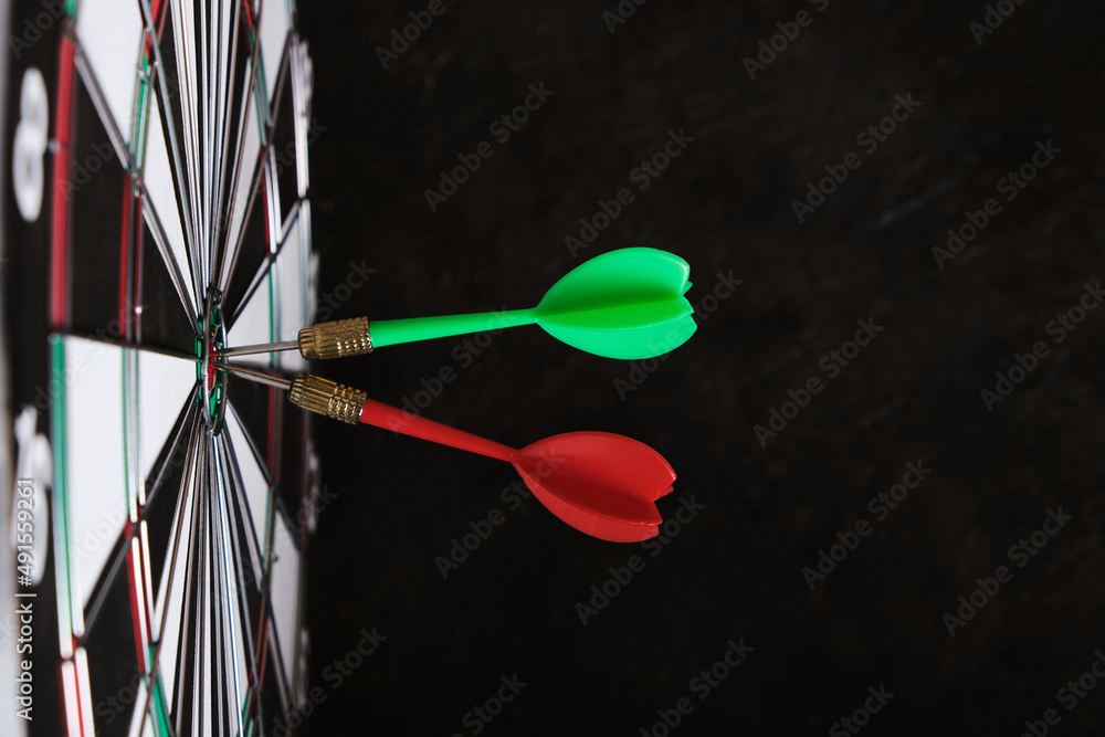 Two darts are stuck in the center of dartboard.Achieving goals in business and in life. Two darts are stuck in the center of dartboard.Achieving goals in business and in life.