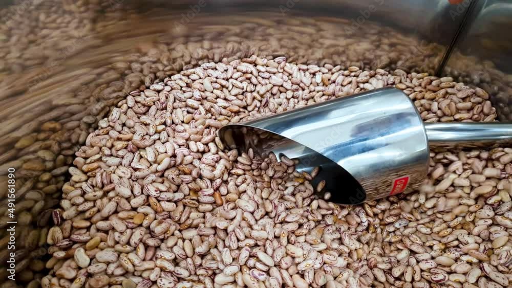 Close up of raw red kidney beans falling from mug in container at the supermarket. Close up of raw red kidney beans falling from mug in container at the supermarket.