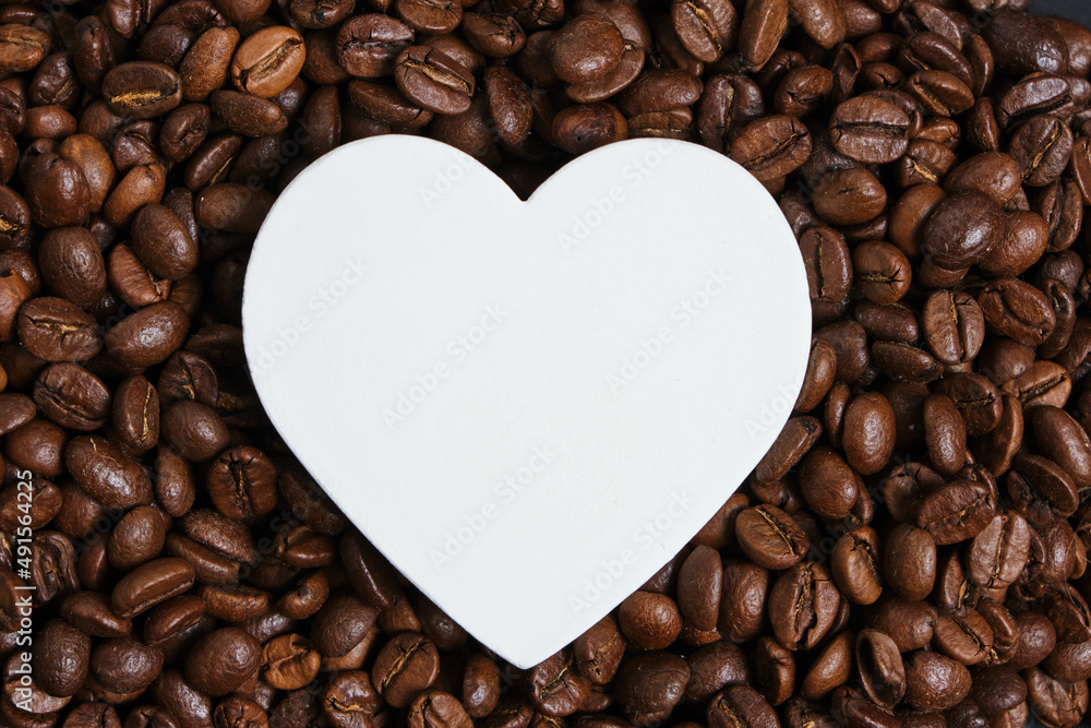 White heart on the background of roasted coffee beans. White heart on the background of roasted coffee beans.