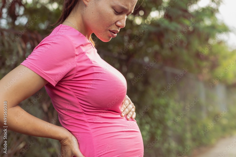 A pregnant woman having pain in her belly and lower back. Prenatal problems and symptoms. A pregnant woman having pain in her belly and lower back. Prenatal problems and symptoms.