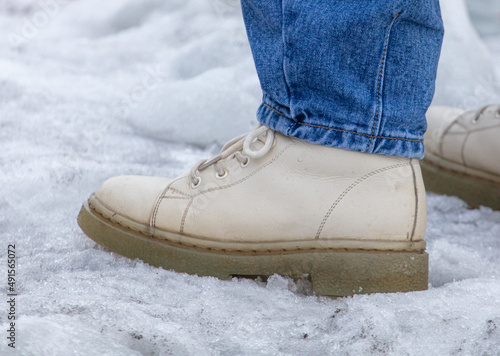 Men's feet in boots on the snow.