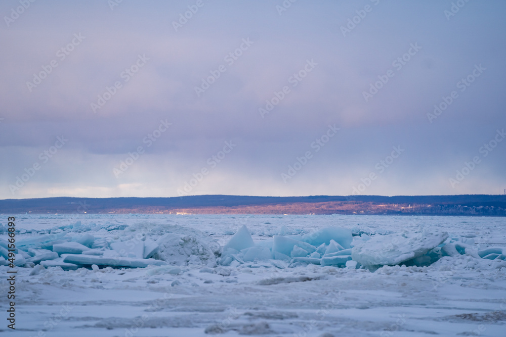 Blue Ice Chunks on Lake Michigan - Frozen Lake with snow, beautiful colorful sky, and clouds in the background Blue Ice Chunks on Lake Michigan - Frozen Lake with snow, beautiful colorful sky, and clouds in the background