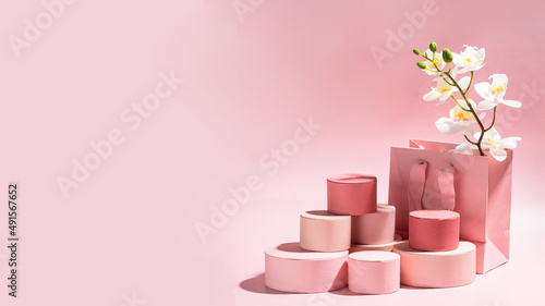 Many round gift boxes with orchid flower on pink pastel background with hard light. Abstract giving surprise present, mocke up or sale concept. banner size with copy space