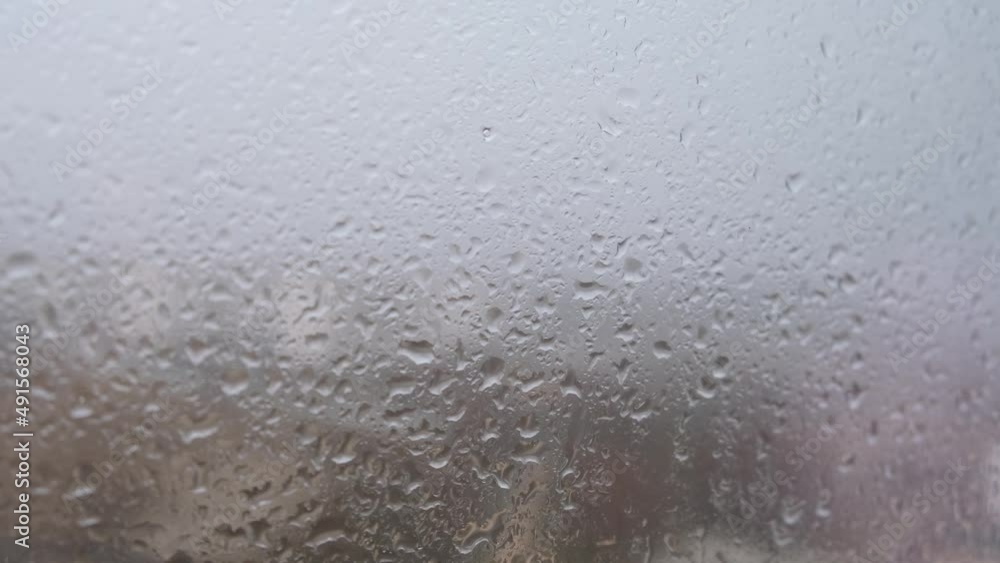 Rain window house. Raindrops trickle down the gray glass. The concept of depression of sadness of longing. Heavy autumn rain. Close-up glass. Abstract cloudy background. Cold weather outside Rain window house. Raindrops trickle down the gray glass. The concept of depression of sadness of longing. Heavy autumn rain. Close-up glass. Abstract cloudy background. Cold weather outside