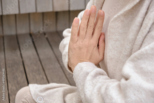 Meditating attractive woman sitting in asana meditative yoga with closed eyes, positive emotions, harmony balance, self-knowledge. Meditation in the park. Positive emotions. Lifestyle