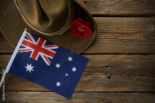 Anzac army slouch hat with Australian Flag and Poppy on wooden background photo